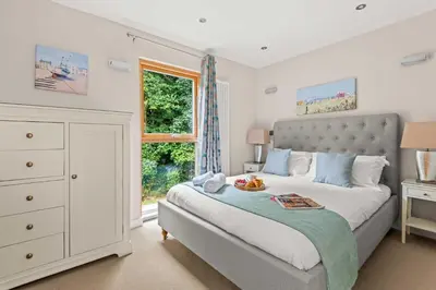a bedroom with a large bed and a window at House 4 in Looe