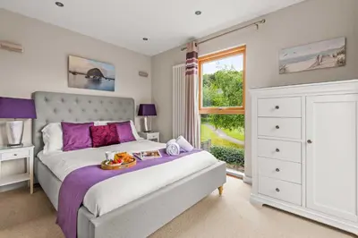 a bedroom with a bed with a tray of food on it at House 4 in Looe
