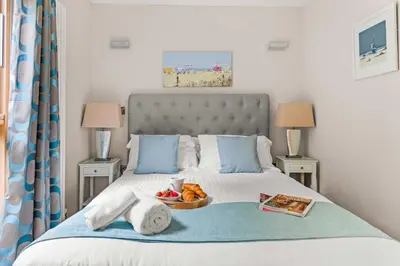 a bedroom with a bed with a tray of food on it at House 4 in Looe