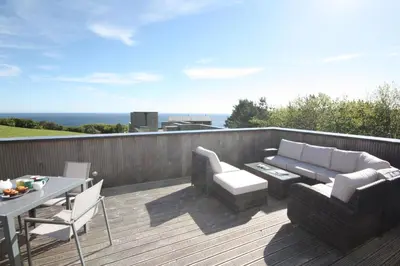 a patio with a couch and chairs and a table at House 45 in Looe