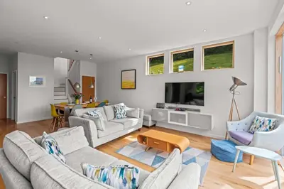 a living room with couches and a tv at House 45 in Looe