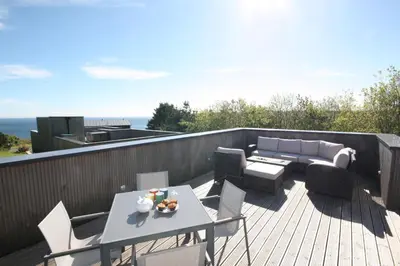 a patio with a table and chairs on a deck at House 45 in Looe