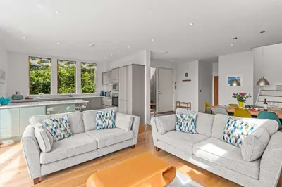 a living room with two couches and a kitchen at House 45 in Looe