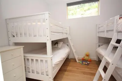 two white bunk beds in a white room at House 47 in Talland