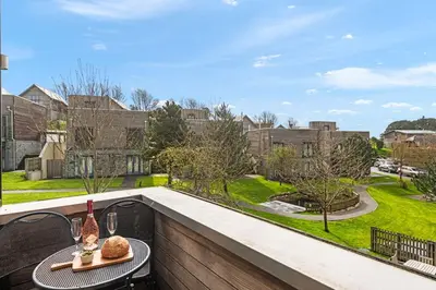 a table on a balcony with a view of a yard at House 5 in Looe