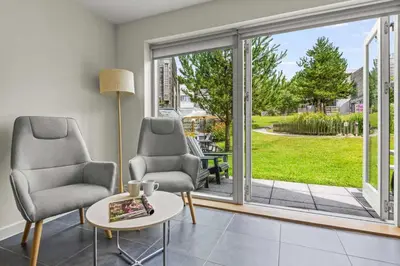 a living room with two chairs and a table at House 8 in Looe