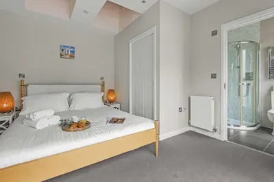 a bedroom with a bed with a tray of fruit on it at House 8 in Looe