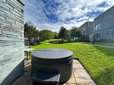 a barrel sitting on a patio next to a building at House 8 in Looe