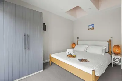 a bedroom with a bed with a bowl of fruit on it at House 8 in Looe
