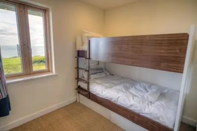 a bed in a room next to a window at House 42 in Looe
