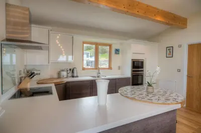 a kitchen with a white counter top and a sink at House 42 in Looe