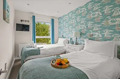 a bedroom with two beds with a tray of fruit at House 9 in Looe