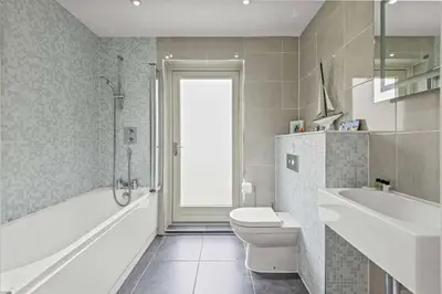 a bathroom with a tub and a toilet and a sink at House 9 in Looe