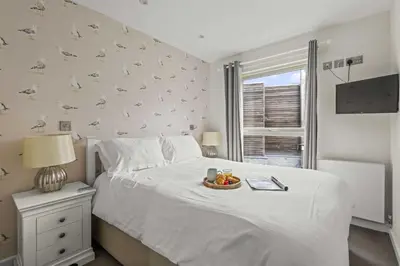 a bedroom with a bed with a bowl of fruit on it at House 9 in Looe