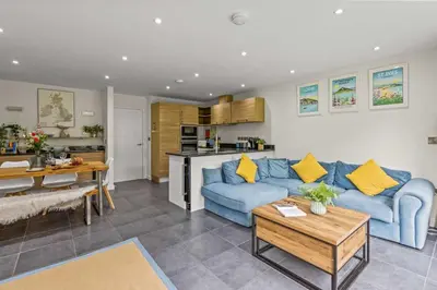 a living room with a blue couch and a table at House 9 in Looe