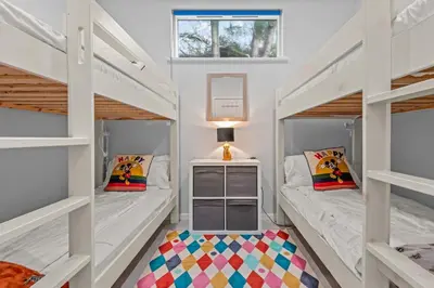 two bunk beds in a small room with a window at House 46 in Looe