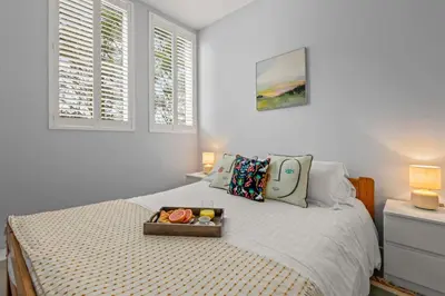 a bedroom with a bed with a tray of food on it at House 46 in Looe