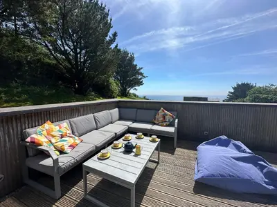a couch and a coffee table on a deck at House 46 in Looe