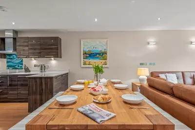 a living room with a wooden table and a couch at House 7 in Looe