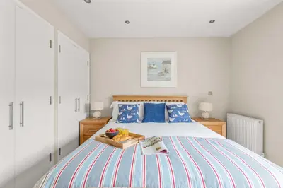 a bedroom with a bed with a tray of fruit on it at House 7 in Looe