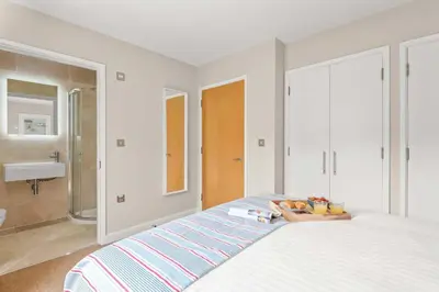a bedroom with a bed with a bowl of fruit on it at House 7 in Looe