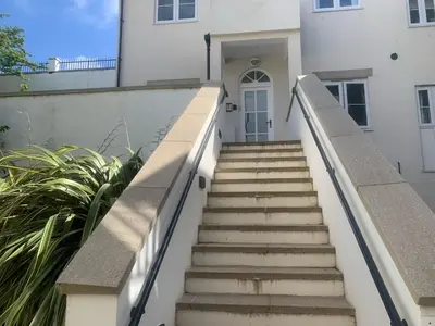 a set of stairs leading to a white house at Stunning 2 bedroom modern apartment! Amazing views! in Carbis Bay