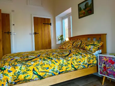 a bedroom with a bed with a colorful comforter at The Jeep House in the Area of Outstanding Natural Beauty in Liskeard