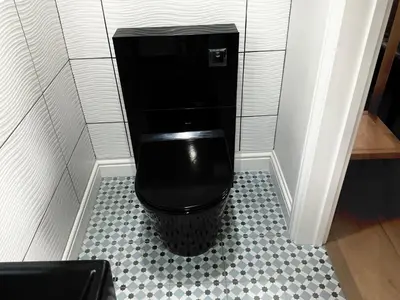 a bathroom with a black toilet in a stall at The Jeep House in the Area of Outstanding Natural Beauty in Liskeard