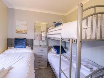 two bunk beds in a room with a mirror at Lodge 9 - Lamorna in Padstow