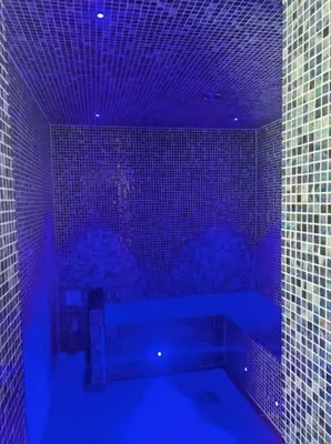 a blue bathroom with a tub with blue lights at Sandy Nights in Tywardreath