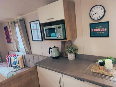 a kitchen with a counter and a microwave in a caravan at Sandy Nights in Tywardreath
