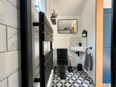 a small bathroom with a toilet and a sink at Luxury Shepherds Hut With Wood Fired Hot Tub in Mawgan Porth