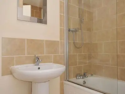 a bathroom with a sink and a shower at 9 Slipway Cottages in Wadebridge