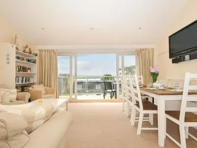 a living room with a table and a dining room at 9 Slipway Cottages in Wadebridge