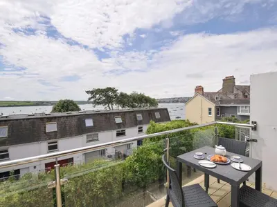 an apartment balcony with a table and chairs at 9 Slipway Cottages in Wadebridge