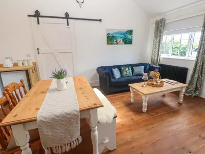 a living room with a table and a couch at Lavender Cottage in Helston
