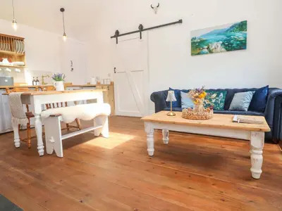 a living room with a couch and a table at Lavender Cottage in Helston