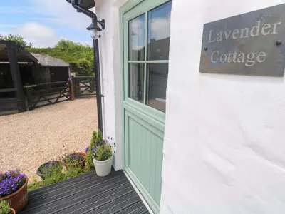 a door to a lavender cottage with a sign on it at Lavender Cottage in Helston