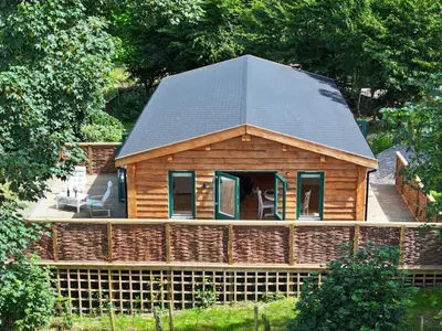 a log cabin with a gambrel roof at Owl Lodge in Liskeard