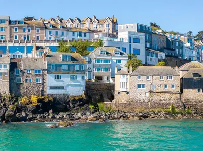 a group of houses on a hill next to the water at Blue Mist Studio in St Ives