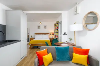 a living room with a couch with colorful pillows at Blue Mist Studio in St Ives