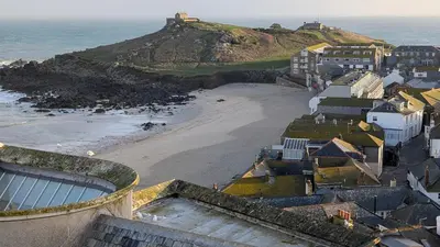 a view of a beach with houses and the ocean at Tate Five Penthouse apartment with panoramic views of St Ives in St Ives