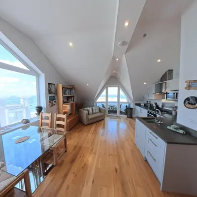a kitchen and living room with a large window at Tate Five Penthouse apartment with panoramic views of St Ives in St Ives