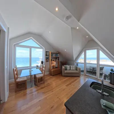 a kitchen and living room with a view of the ocean at Tate Five Penthouse apartment with panoramic views of St Ives in St Ives
