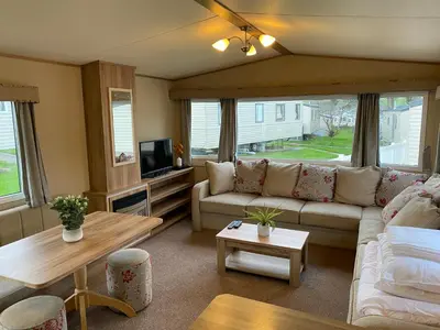 a living room with a couch and a tv at Cornish Caravan Escapes in Porth