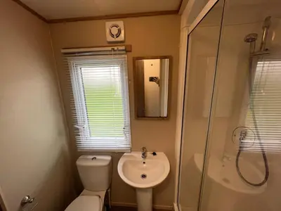 a bathroom with a toilet and a sink and a shower at Cornish Caravan Escapes in Porth