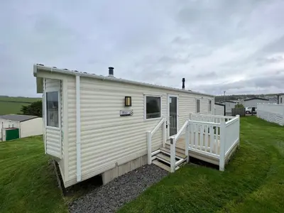a white tiny house on a grass field at Cornish Caravan Escapes in Porth