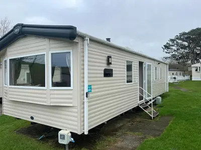 a white trailer is parked in a yard at Cornish Caravan Escapes in Porth