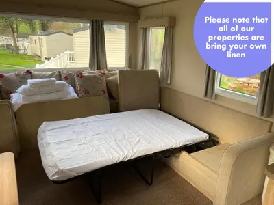 a small room with a bed and a couch at Cornish Caravan Escapes in Porth