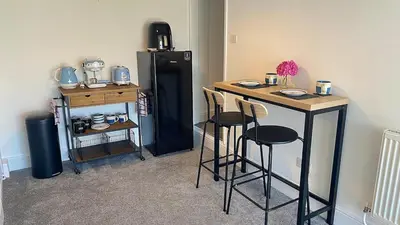 a kitchen with a table and a black refrigerator at Sea view Studio by Fistral Beach in Newquay